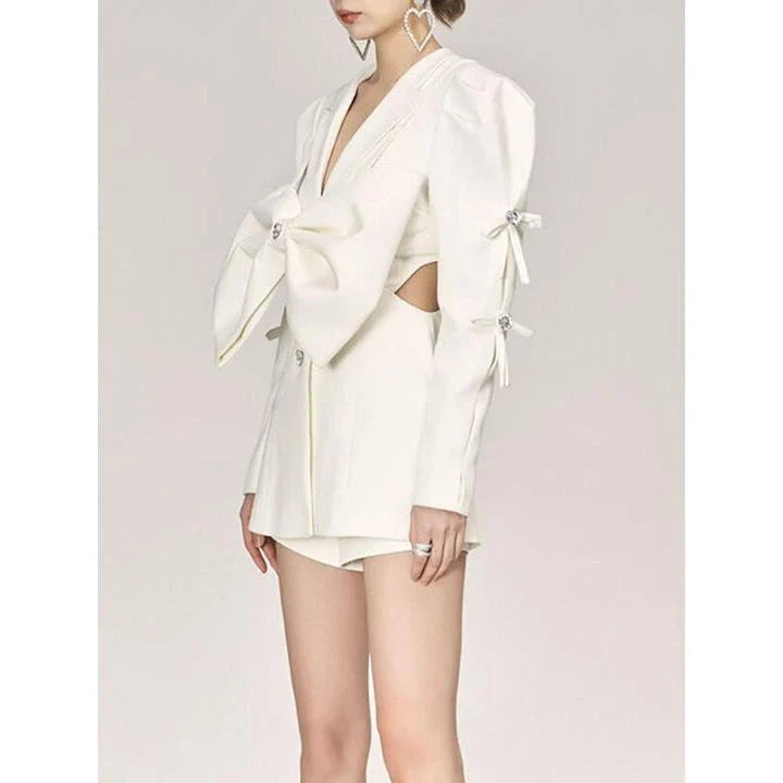 Stylish women's white blazer with a sparkling diamond bow accent, designed for fashion-forward British women