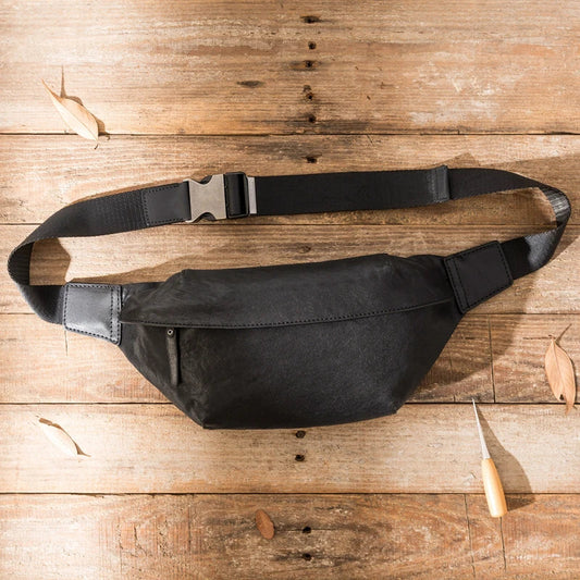 Premium cowhide messenger bag in black, featuring a spacious interior, adjustable shoulder strap, and sleek, minimalist design