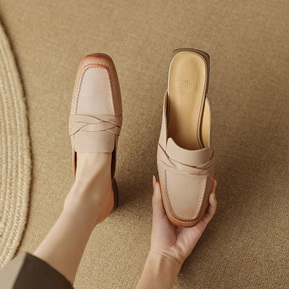 Stylish leather mules in a khaki colour, featuring a low square heel and a sleek, shallow-cut design for a retro-inspired, sophisticated look.