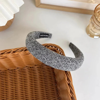 A stylish wide hairband in a classic plaid pattern, offering a chic and sophisticated look for British women.