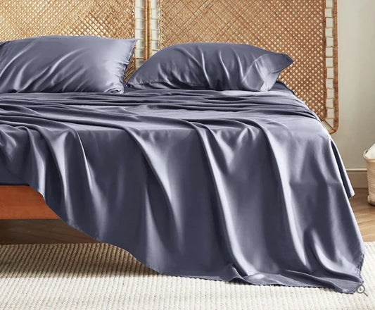 Premium bamboo fibre bed sheets in a classic solid purplish blue colour, featuring a four-piece set including a fitted sheet, flat sheet, and two pillowcases.