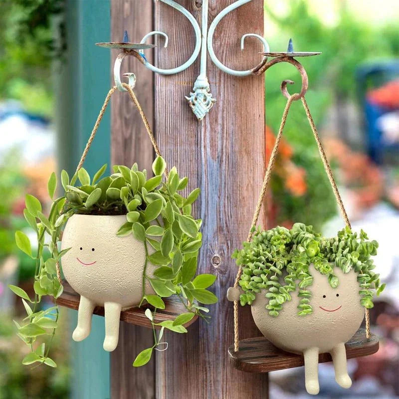 A white hanging planter with a charming, smiling child's face design, perfect for indoor or outdoor use.