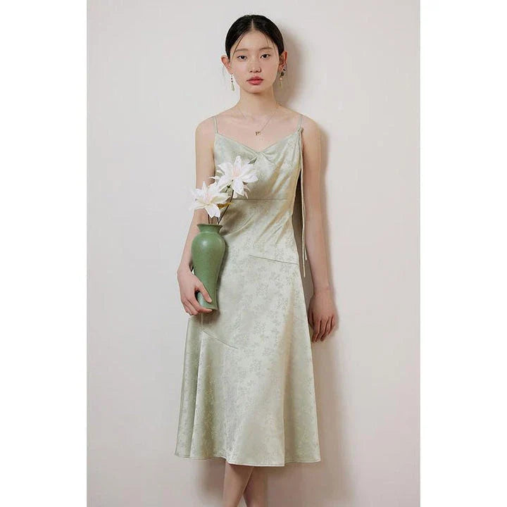 Elegant mint green midi dress with spaghetti straps, featuring a flattering slim fit and beautiful embroidery detailing