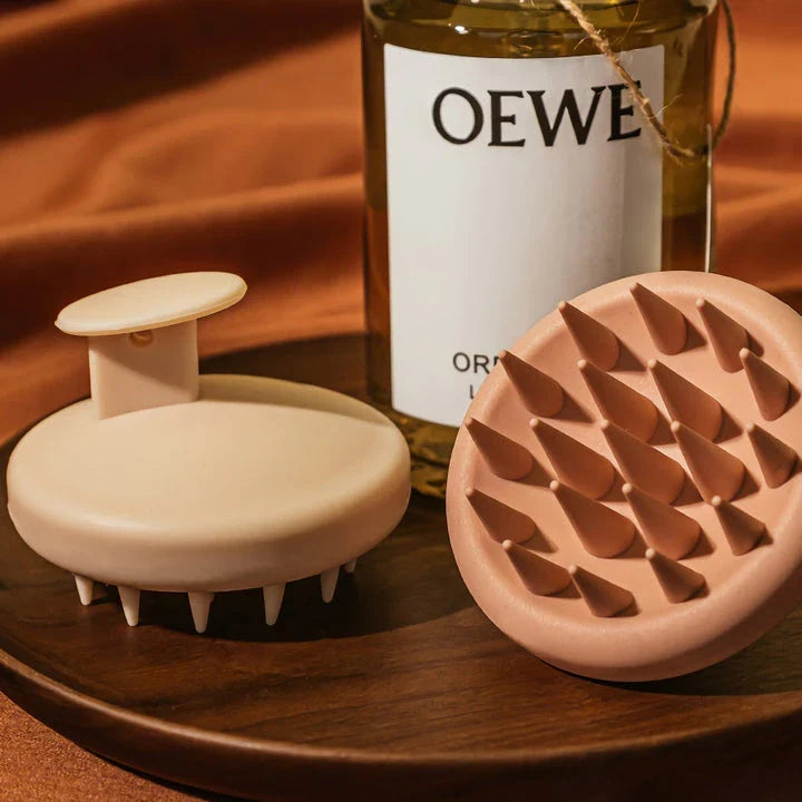 A green silicone scalp massager with soft bristles, designed to provide a soothing hair washing experience and promote healthy hair growth.
