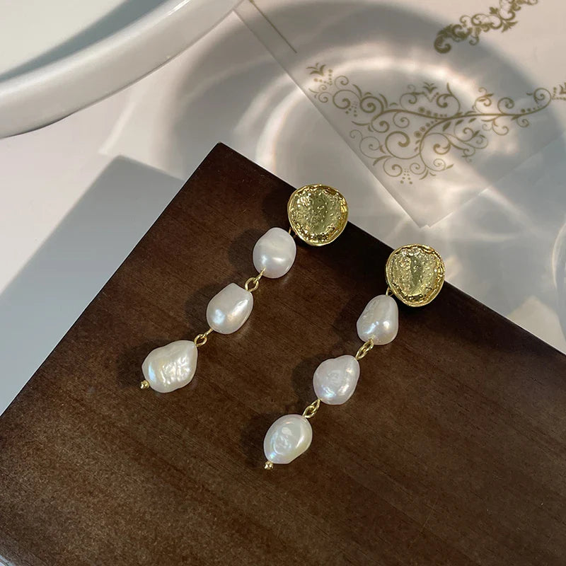 Elegant pearl and gold plated earrings with a long, eye-catching design