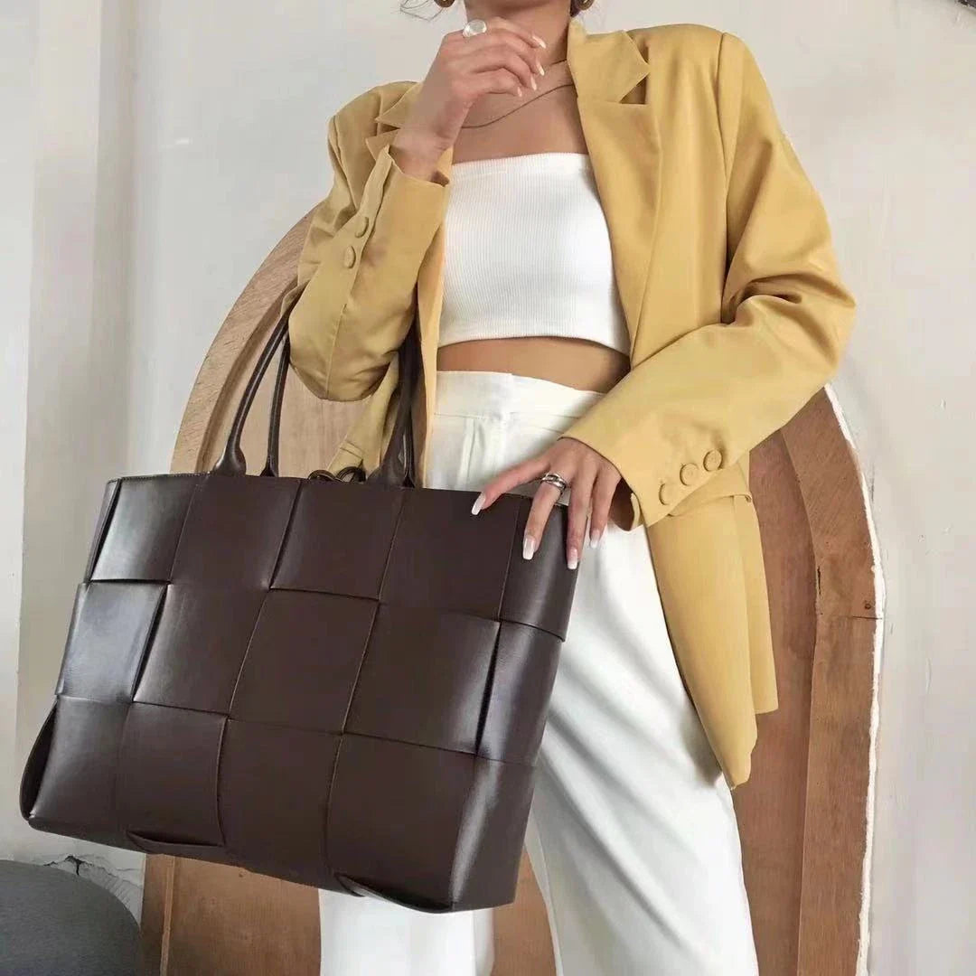 Exquisitely crafted leather tote bag with a timeless woven design, embodying British elegance and quality.