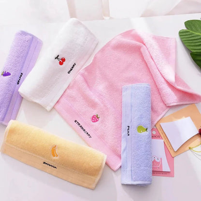 Soft cotton baby bath towel with adorable cartoon fruit face designs in pink