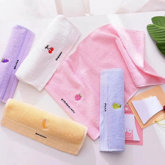 Soft cotton baby bath towel with adorable cartoon fruit face designs in pink