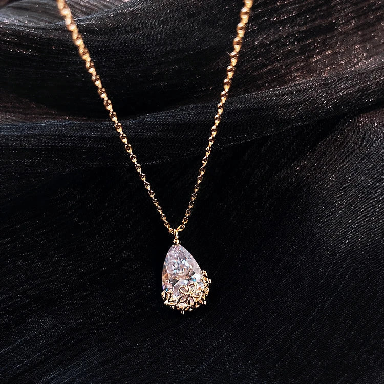 Close-up shot of a silver-plated crystal water drop pendant necklace on a plain background