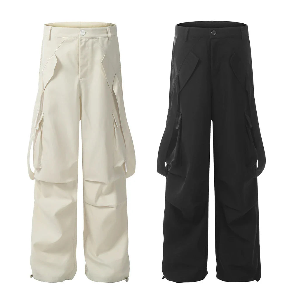 Stylish black pleated overalls with ribbon pockets, a versatile and refined menswear piece.