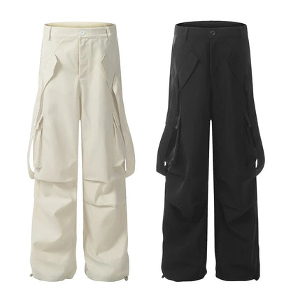 Stylish black pleated overalls with ribbon pockets, a versatile and refined menswear piece.