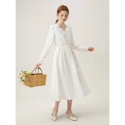 A woman wearing a long-sleeved, midi-length dress in a French pastoral style with an empire waistline and A-line silhouette.