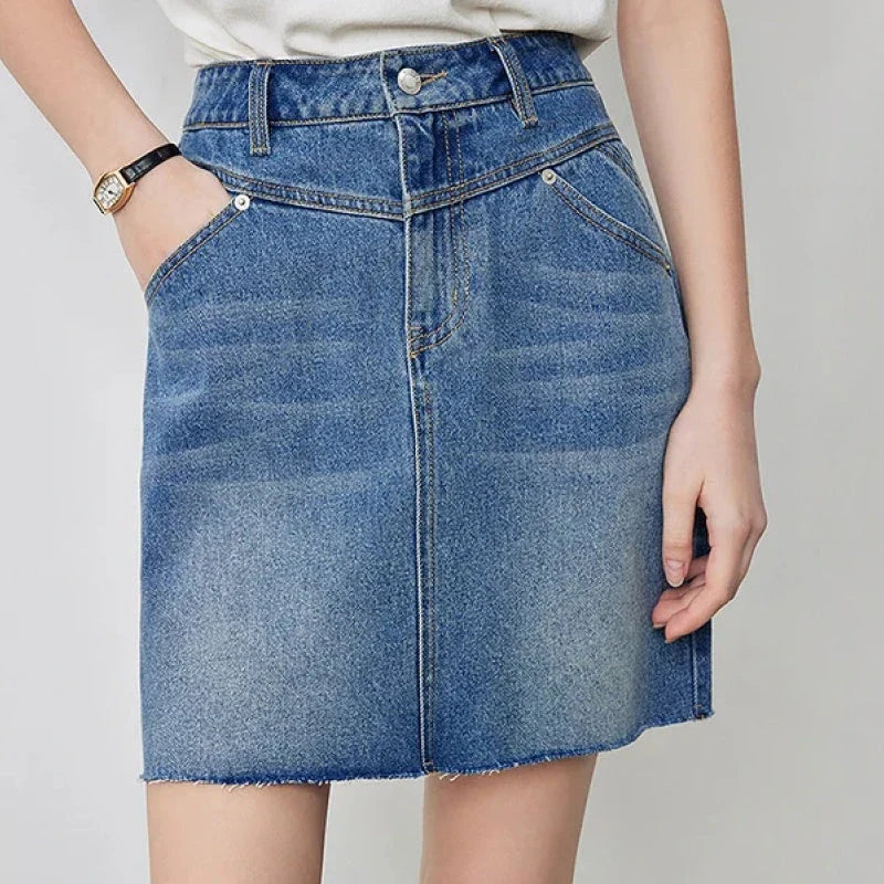 Sophisticated lyocell denim mini skirt with classic A-line silhouette and functional pockets for the discerning British woman
