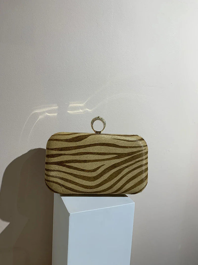 A premium handcrafted messenger bag made with luxurious horsehair and featuring a unique colourful brick ring buckle closure, showcasing the timeless charm of British craftsmanship.