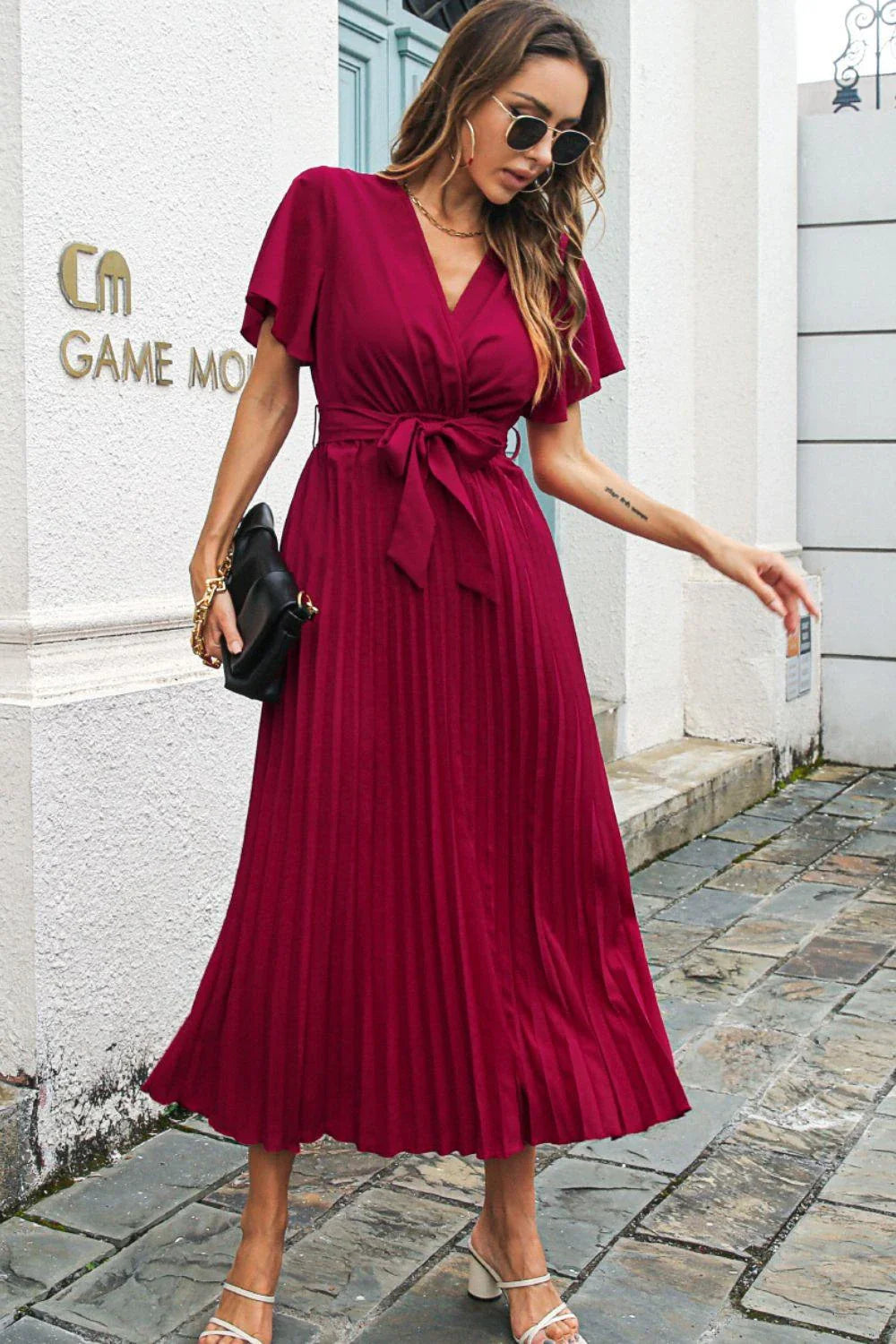 Elegant black midi dress with belted waist and flutter sleeves, perfect for any occasion