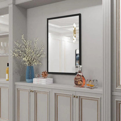 Sophisticated black metal framed wall mirror with rounded corners, reflecting a bright and spacious room