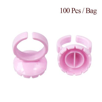 Heart-shaped disposable eyelash glue rings in blue, pink, and white colours