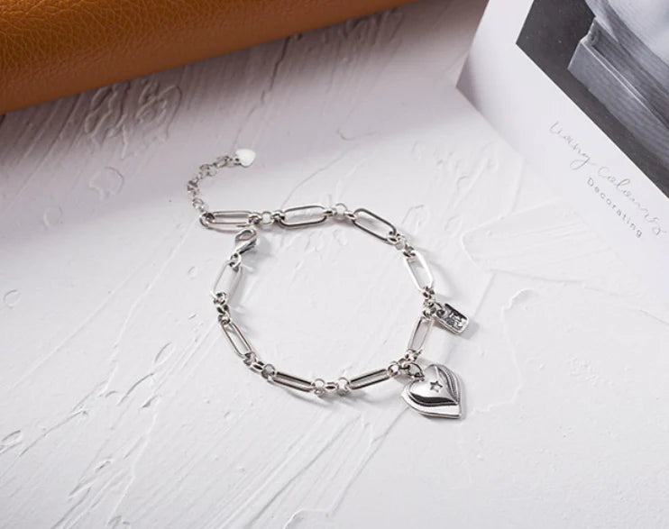 Elegant sterling silver bracelet with a delicate heart charm, a timeless accessory for the modern British woman.