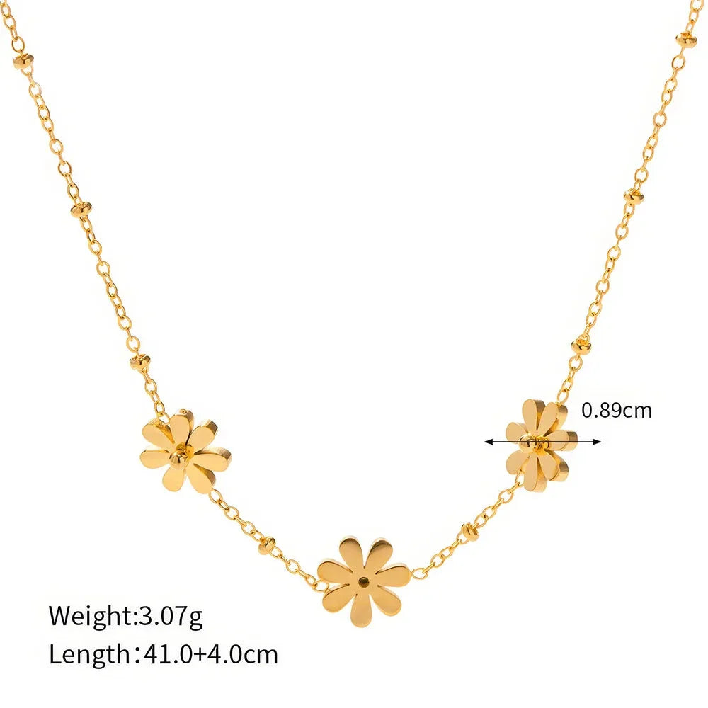 Exquisite 18-carat gold-plated necklace featuring three delicate daisy pendants on a stainless steel chain, embodying timeless British elegance and sophistication.