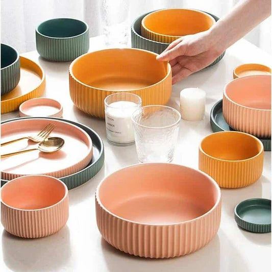 Candy-coloured ribbed ceramic tableware featuring plates, bowls, and other dining accessories in vibrant hues