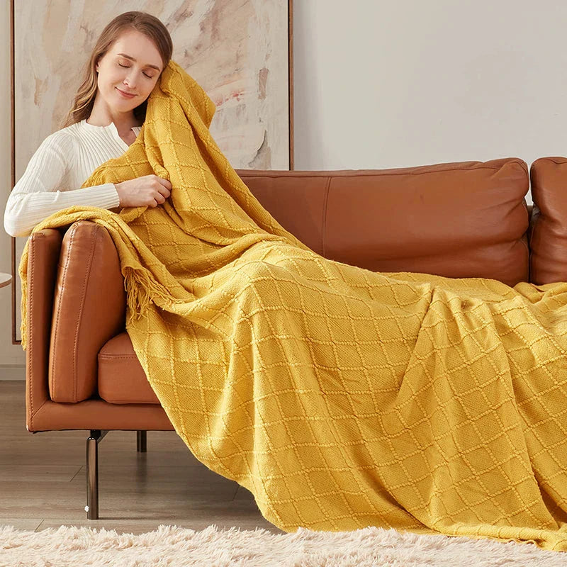 Cosy mustard yellow knitted throw blanket with raised diamond pattern and tassel fringes, providing soft and warm comfort for living rooms, bedrooms, and outdoor use.