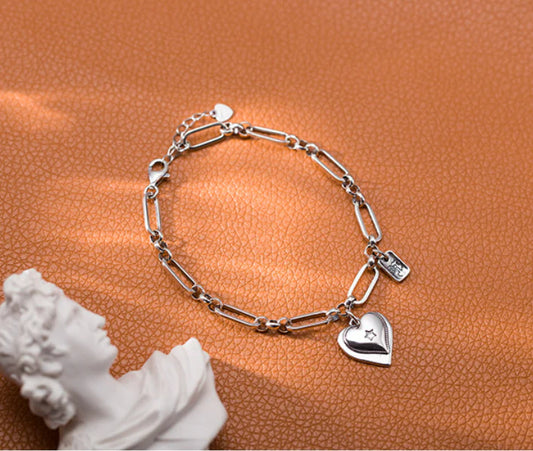Elegant sterling silver bracelet with a delicate heart charm, a timeless accessory for the modern British woman.