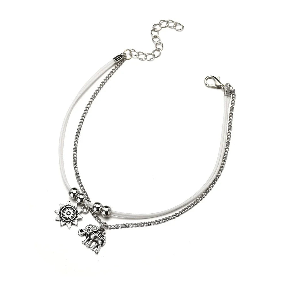 Elegant bohemian-style anklet with star and elephant charms in shimmering gold and silver tones