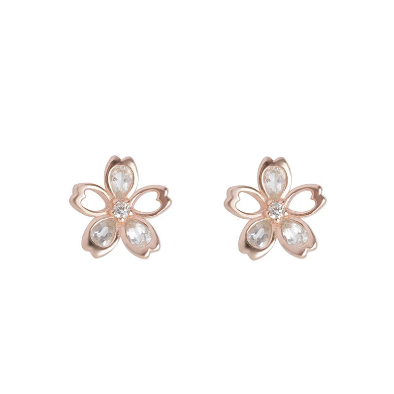 Pair of elegant zircon cherry blossom earrings in skin colour, featuring a delicate floral design and sparkling stones