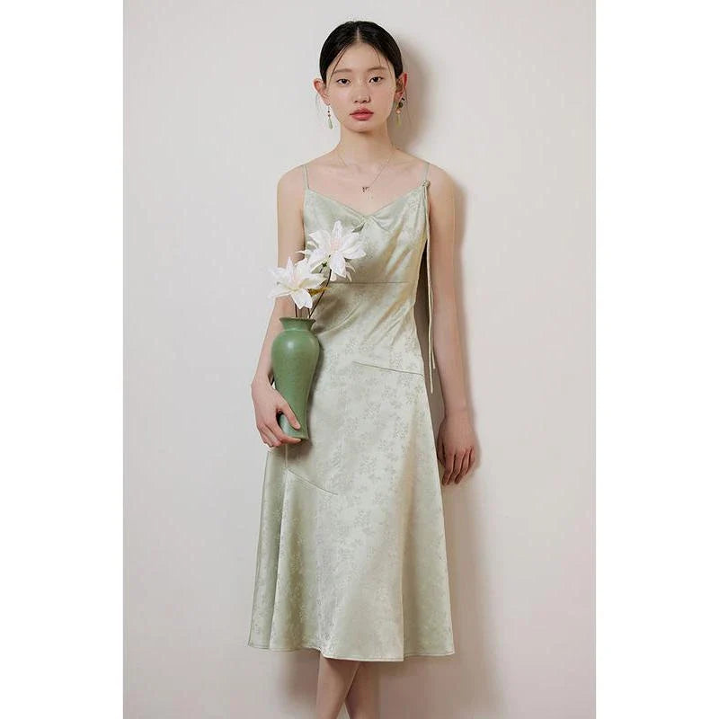 Elegant mint green midi dress with spaghetti straps, featuring a flattering slim fit and beautiful embroidery detailing