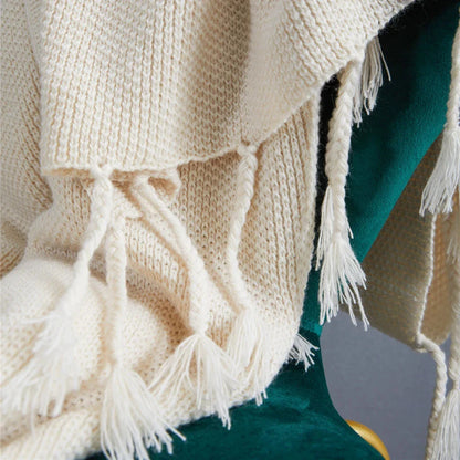 Luxurious Nordic-style wool knitted throw blanket in grey colour, featuring a solid pattern and elegant tassel design