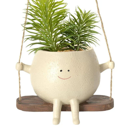 A white hanging planter with a charming, smiling child's face design, perfect for indoor or outdoor use.