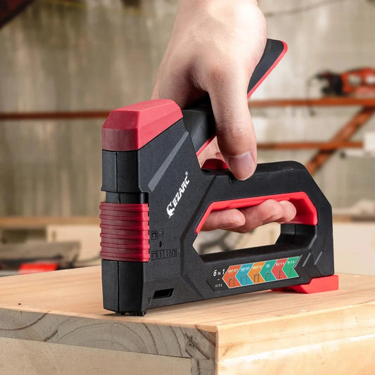 A heavy-duty manual staple gun with a black body and rubber grip, capable of driving multiple types of fasteners for a variety of DIY projects.