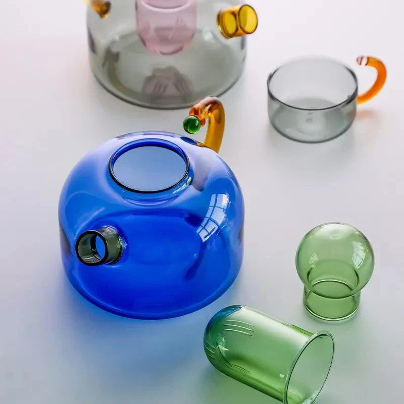 Elegant colourful glass teapot and teacup set with vibrant contrasting colours, perfect for tea and coffee enjoyment