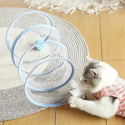 Folding cat play tunnel with various toys like balls, feathers, and mice attached to the sides