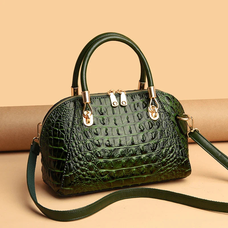 Premium leather one-shoulder messenger bag in various colours, featuring a sleek, shell-inspired silhouette and multiple internal pockets for organisation.