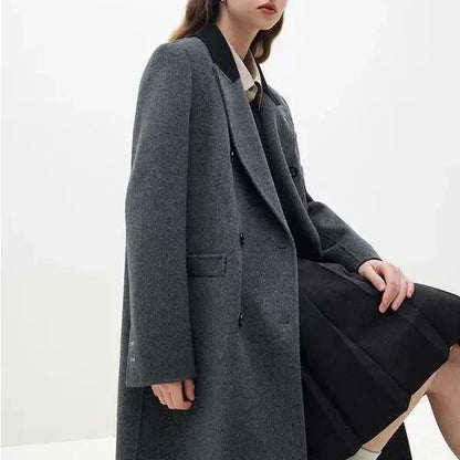 A sophisticated and stylish dark grey woollen coat for women, designed with a timeless double-breasted closure and notched collar.