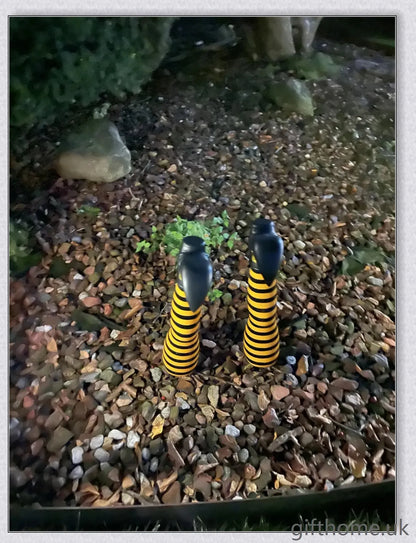 Animated witch legs in various colours, including purple, yellow, and black and white, kicking and moving to create a spooky Halloween display