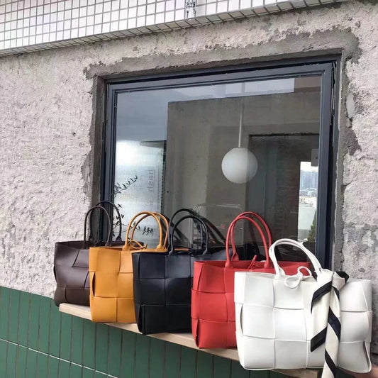 Exquisitely crafted leather tote bag with a timeless woven design, embodying British elegance and quality.