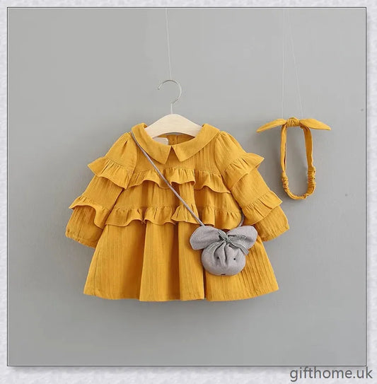 A beautiful summer dress for girls with a delicate floral pattern, long sleeves, and included accessories like a hair accessory and handbag