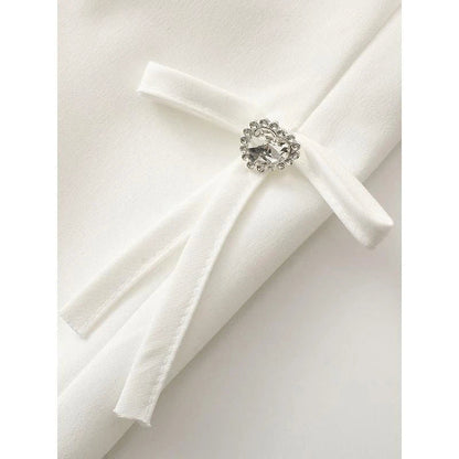 Stylish women's white blazer with a sparkling diamond bow accent, designed for fashion-forward British women