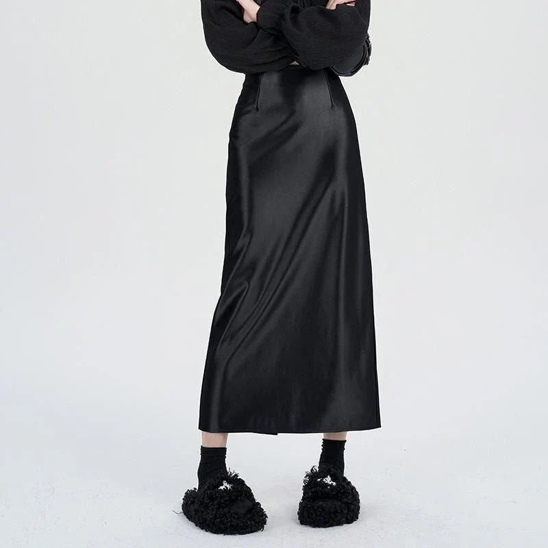 Luxurious silver satin maxi skirt with high-waist design and chic back split for elegant and versatile style.