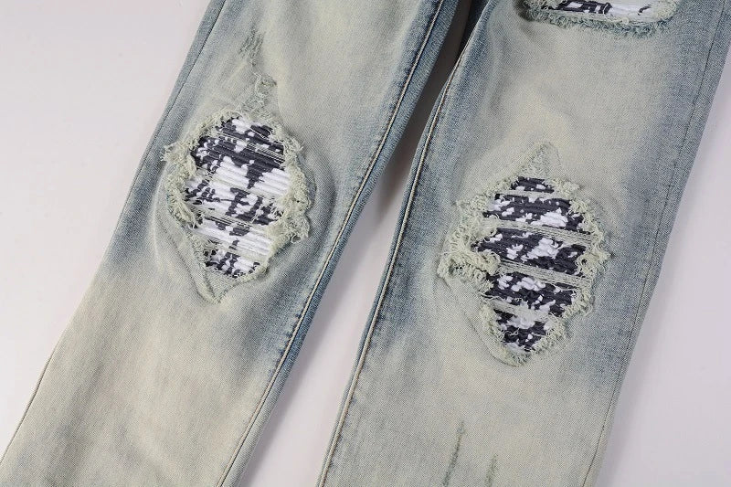Stylish ripped denim jeans with a unique black and white patch design, perfect for British gentlemen