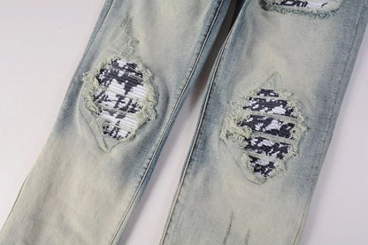 Stylish ripped denim jeans with a unique black and white patch design, perfect for British gentlemen