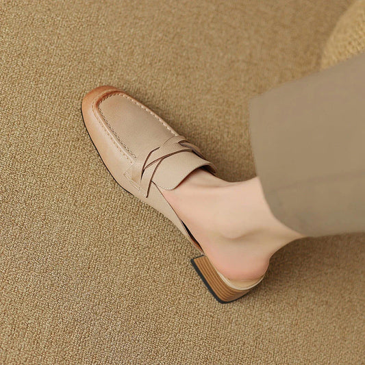 Stylish leather mules in a khaki colour, featuring a low square heel and a sleek, shallow-cut design for a retro-inspired, sophisticated look.