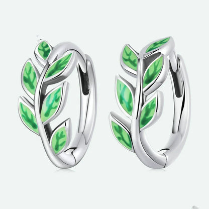 Elegant silver earrings with a fern-inspired design and sparkling green zircon centerpiece