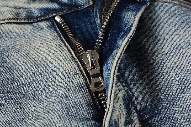 Stylish ripped denim jeans with a unique black and white patch design, perfect for British gentlemen