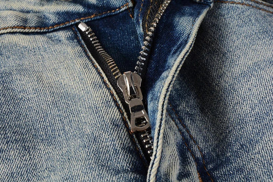 Stylish ripped denim jeans with a unique black and white patch design, perfect for British gentlemen