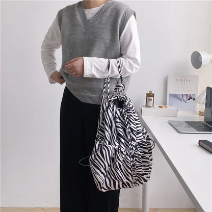 A stylish drawstring bucket bag in white, black, or brown colour options, featuring a spacious interior and adjustable closure for modern British women.