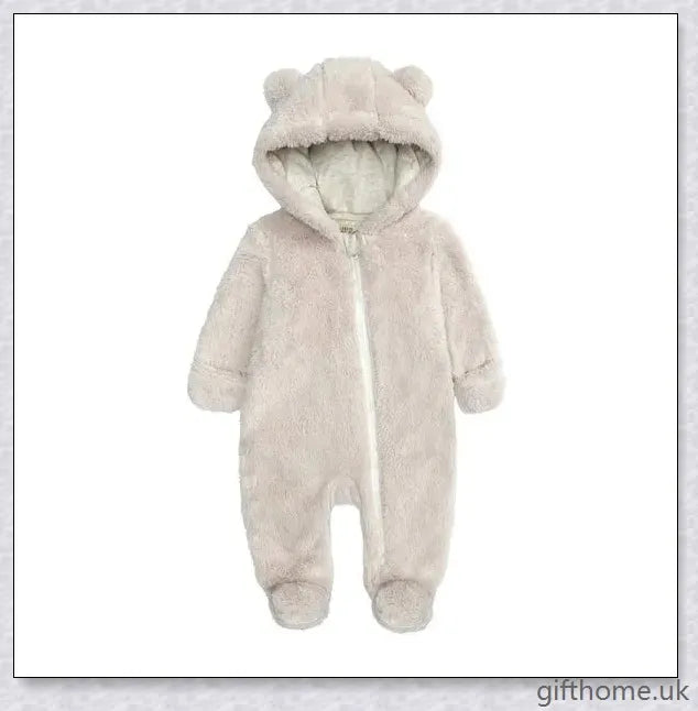 Adorable baby wearing a cosy hooded jumpsuit in blue, pink, or apricot colour