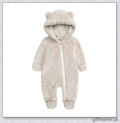 Adorable baby wearing a cosy hooded jumpsuit in blue, pink, or apricot colour